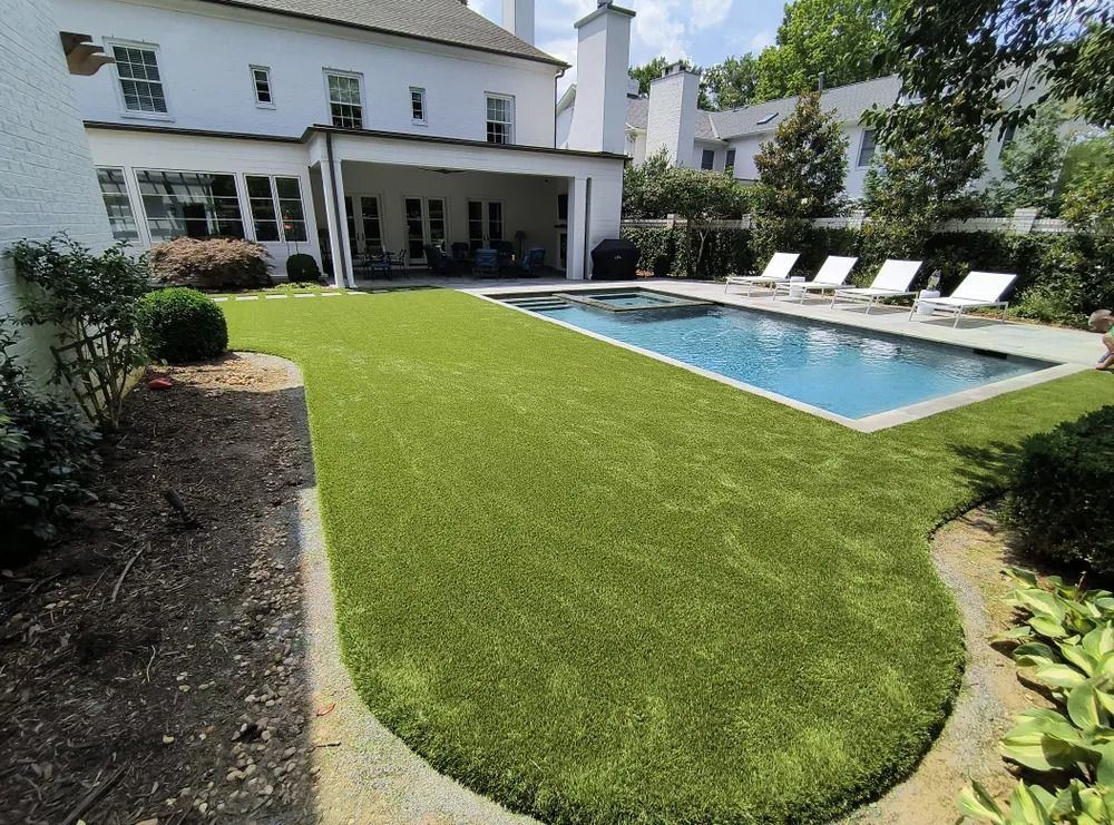 Elite Turfs artificial lawn curving around a backyard pool