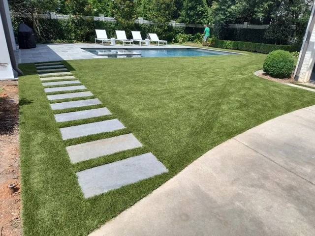 Turf and paver stepping stones around a pool